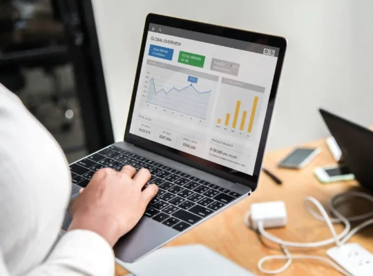 Pessoa analisando dashboard de performance no marketplace em um notebook com gráficos e indicadores de vendas.