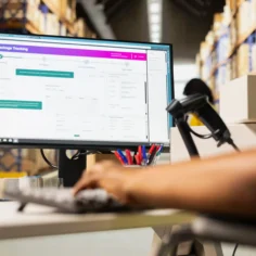 Pessoa utilizando sistema de automação marketplace em um computador para gerenciar pedidos e operações logísticas