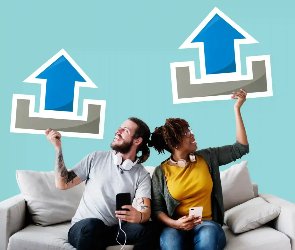 Homem e mulher sentados em um sofá seguram celulares e grandes setas azuis apontadas para cima