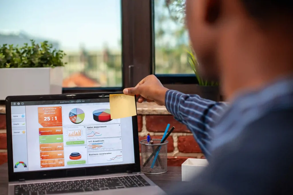 Pessoa analisando um dashboard marketplace em um notebook com gráficos, indicadores e métricas de vendas