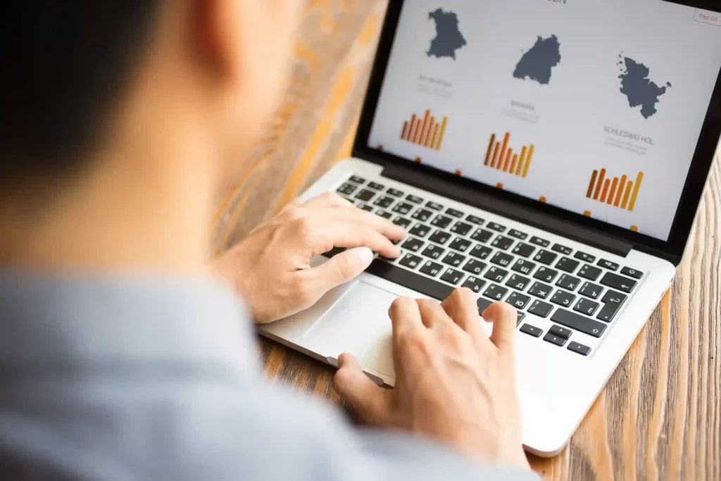 Pessoa analisando gráficos no notebook para representar custos e impostos de compras internacionais