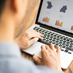 Pessoa analisando gráficos no notebook para representar custos e impostos de compras internacionais