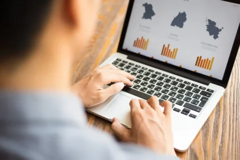 Pessoa analisando gráficos no notebook para representar custos e impostos de compras internacionais