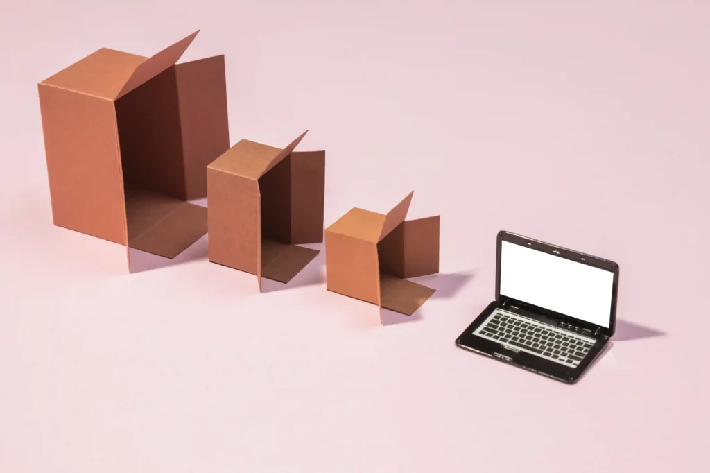 Caixas de papelão abertas em tamanhos diferentes ao lado de um notebook