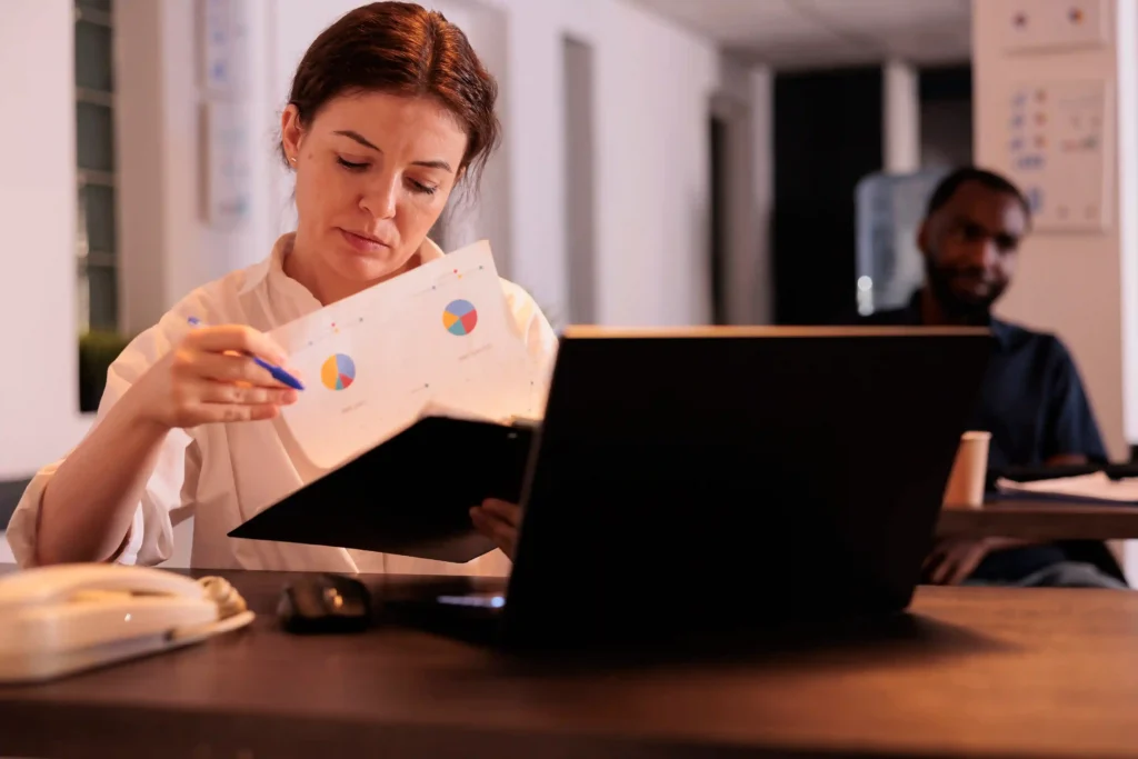 Profissional analisando gráficos de vendas no notebook para avaliar produtos e concorrência no Mercado Livre