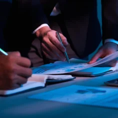 Profissionais analisando relatórios financeiros com gráficos e dados de vendas