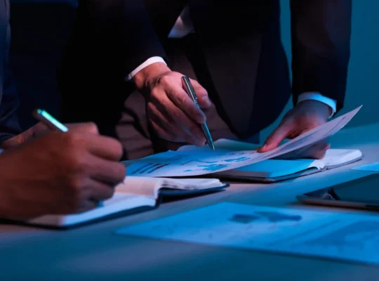 Profissionais analisando relatórios financeiros com gráficos e dados de vendas