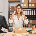 Vendedora em loja com caixas de produtos representando devolução de compras no e-commerce