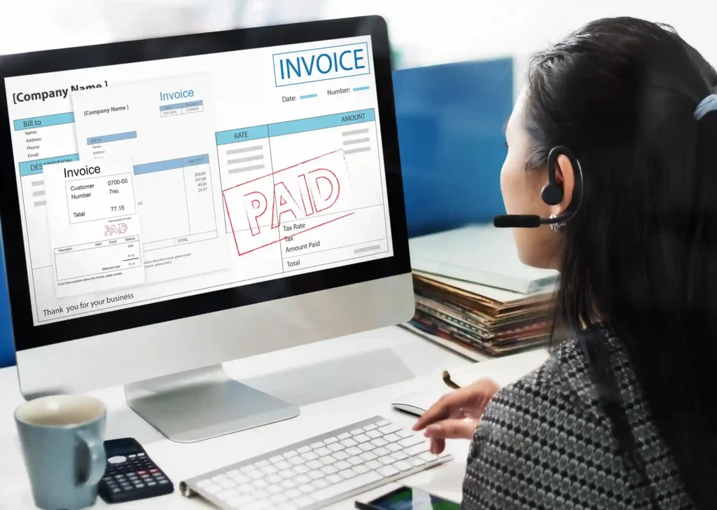 Mulher usando headset diante de computador com notas fiscais e comprovantes de pagamento na tela, representando a emissão de nota fiscal ecommerce para vendas online