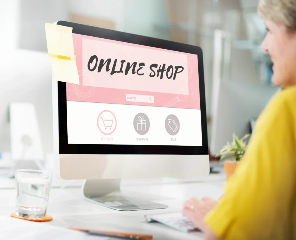 Pessoa utilizando computador com uma página de loja online aberta, exibindo ícones de carrinho de compras, entrega e promoções na tela