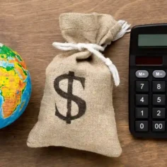 Globo, saco de dinheiro e calculadora representando os diferentes custos envolvidos na importação para revenda