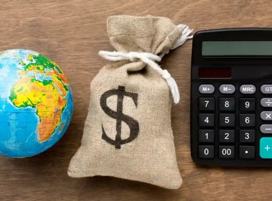 Globo, saco de dinheiro e calculadora representando os diferentes custos envolvidos na importação para revenda