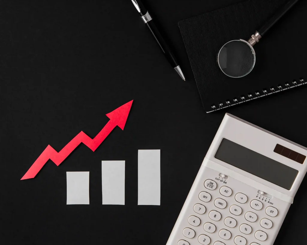Gráfico de barras em crescimento ao lado de calculadora, lupa e caderno