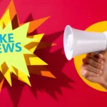 Mão segurando megafone branco ao lado da expressão Fake News sobre fundo vermelho